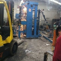 Taller de desmantelamiento con maquinaria pesada y técnicos trabajando