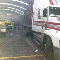 Camión comercial en área de carga con trabajadores